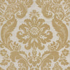 The Shadow Flocked Damask Wallpaper by York Wallcoverings features a tan and cream ornate damask pattern with symmetrical floral and leaf motifs, highlighted by intricate scrolling designs and stylized blossoms on a light background.