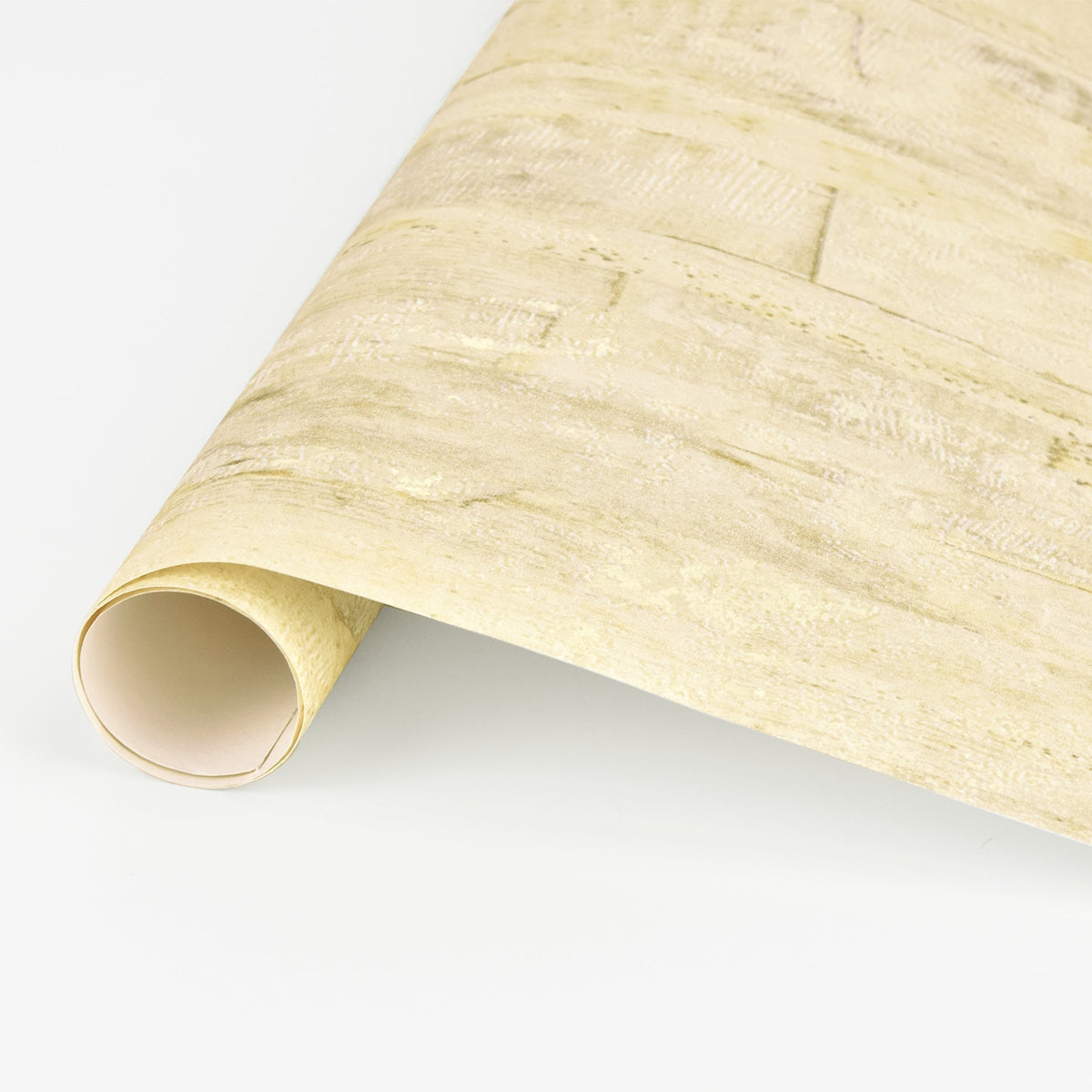 A close-up of a rolled sheet of Lindens Wood Wallpaper by York Wallcoverings in light beige, featuring a subtle textured pattern and displayed on a white surface.