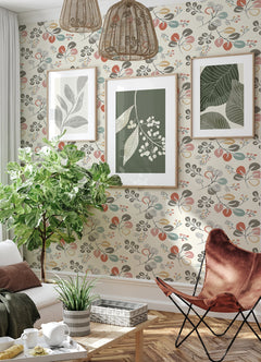 Sunlit living room featuring York Wallcoverings’ Jonah Leaf Trail Wallpaper, with botanical art prints on the wall, a large leafy potted plant, wicker pendant lights, modern furniture, and sheer white curtains at the window.