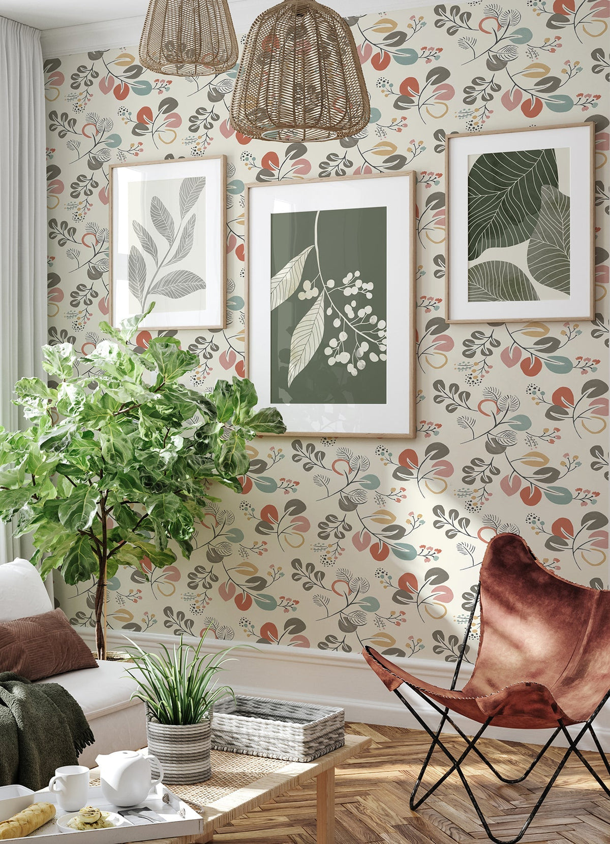 A cozy living room featuring Jonah Leaf Trail Wallpaper by York Wallcoverings, three botanical prints on the wall, a large leafy plant, wicker light fixtures, and a brown butterfly chair beside a small white coffee table topped with a plant.
