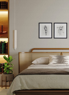 A modern bedroom featuring a wooden bed with beige bedding, a green potted plant, built-in bookshelves, and two framed line art drawings above the headboard on a York Wallcoverings Lars Retro Wave Wallpaper accent wall.