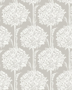 The Zaria Topiary Wallpaper by York Wallcoverings showcases a symmetrical, vintage-inspired design with repeating white, intricate tree-like motifs—featuring leaves and flowers—set against a light beige background.