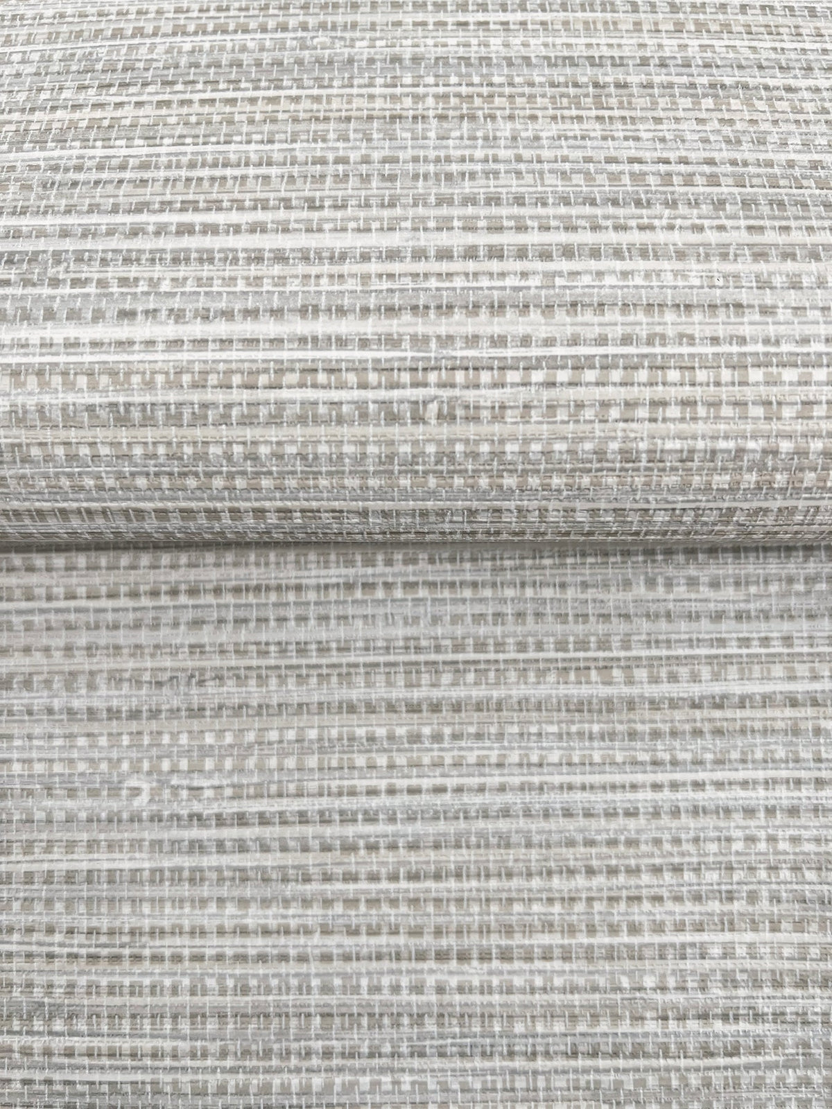 A close-up of folded Winn Faux Grasscloth Wallpaper by York Wallcoverings, featuring a neutral-toned, woven grasscloth texture.