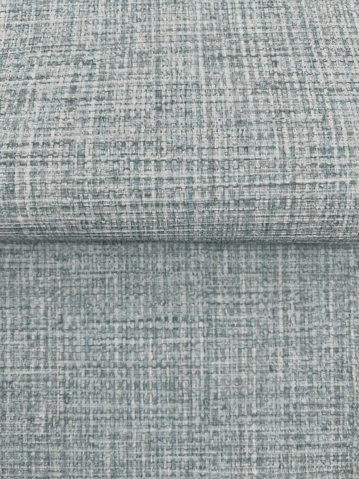 Clarkson Woven Wallpaper featuring a textured, woven pattern in shades of blue, gray, and white.