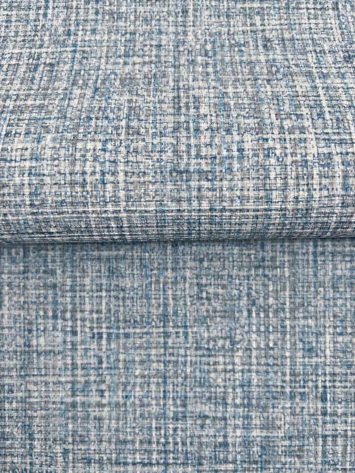 Clarkson Woven Wallpaper featuring a textured, cross-hatched pattern in shades of blue, grey, and white.