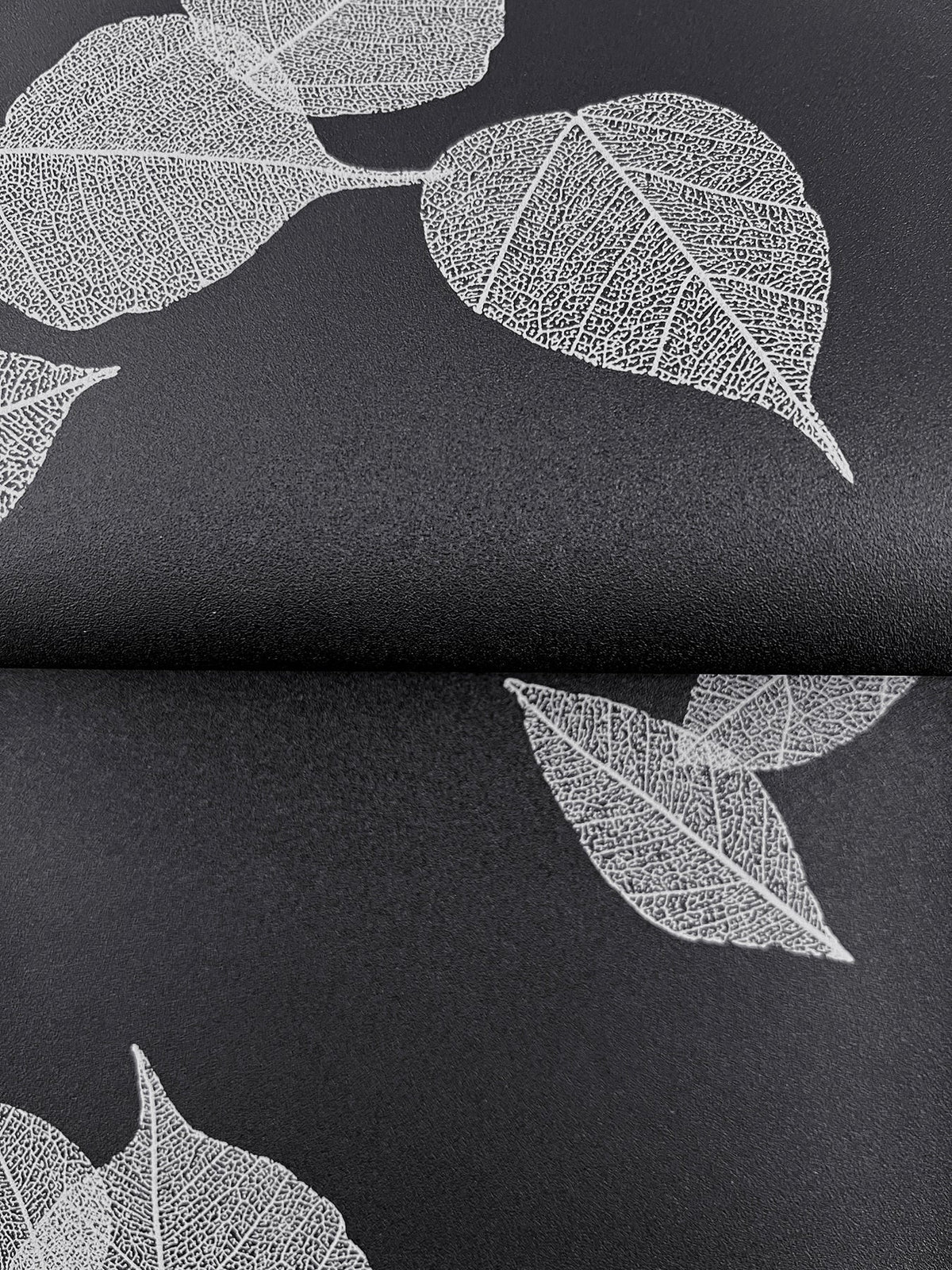 Myles Leaves Wallpaper featuring a pattern of white skeleton leaves on a black background.