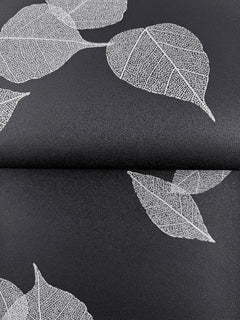 Myles Leaves Wallpaper featuring a pattern of white skeleton leaves on a black background.