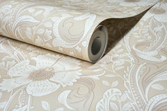 A close-up of the Chesapeake Liora Floral Trail Wallpaper by York Wallcoverings, featuring a textured floral and leaf pattern in beige, partially unrolled on a flat surface.