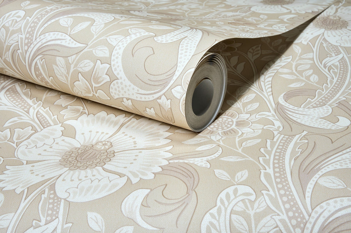 A partially unrolled roll of Chesapeake Liora Floral Trail Wallpaper by York Wallcoverings, showcasing its beige background adorned with large floral and leaf patterns on a flat surface.