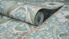The Chesapeake Liora Floral Trail Wallpaper by York Wallcoverings, featuring a floral and leafy pattern in muted green, blue, cream, and soft pink tones, is shown partially unrolled against a matching background.