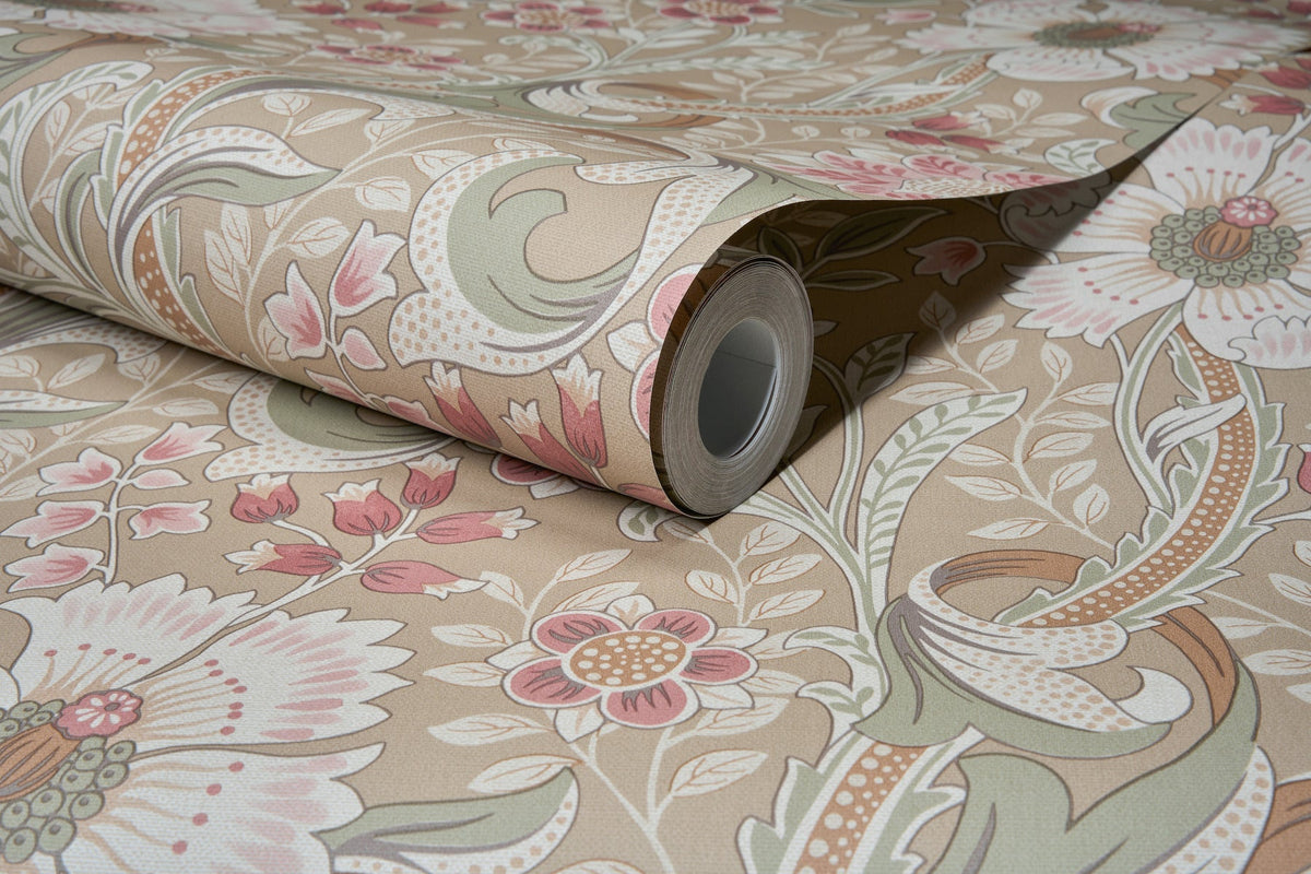A close-up of the Chesapeake Liora Floral Trail Wallpaper by York Wallcoverings, partially unrolled to reveal its intricate floral and leaf pattern in soft beige, pink, and green tones.
