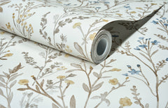 A partially unrolled roll of Chesapeake Laverne Wildflowers Wallpaper by York Wallcoverings features a botanical pattern with brown, yellow, and blue flowers and leaves on a white background.