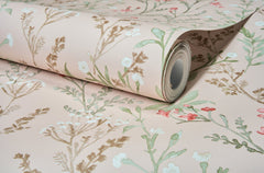 The York Wallcoverings Chesapeake Laverne Wildflowers Wallpaper, featuring a floral pattern in soft green, brown, white, and pink hues, is shown partially unrolled on a flat surface.