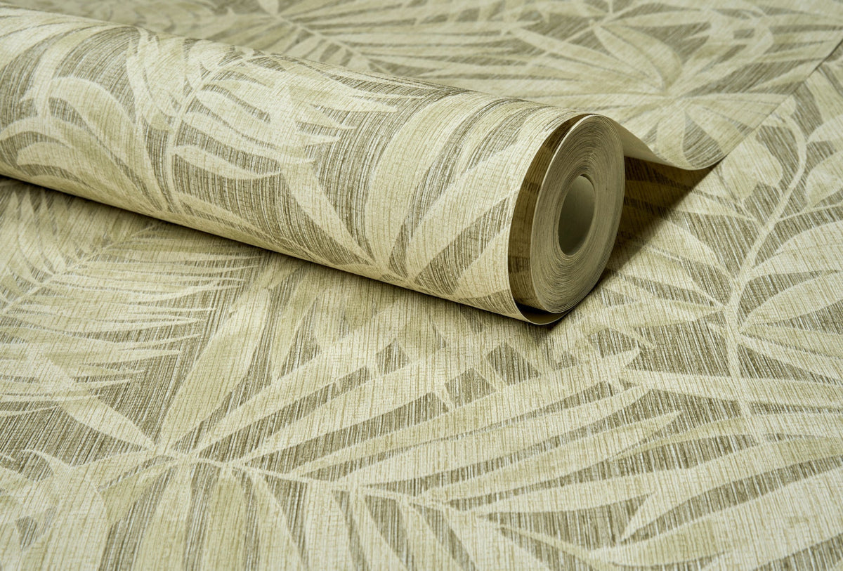 A partially unrolled roll of York Wallcoverings Chesapeake Sonny Fronds Wallpaper in beige, featuring a subtle palm leaf pattern with light, natural tones and a textured finish, displayed on a matching surface.