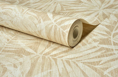 A close-up of the Chesapeake Sonny Fronds Wallpaper by York Wallcoverings, featuring a rolled beige design with a subtle leaf pattern in light cream tones, displayed on a flat surface.
