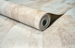 A close-up of a partially unrolled roll of York Wallcoverings Chesapeake Cassandra Block Geometric Wallpaper in beige, lying on a matching flat surface.