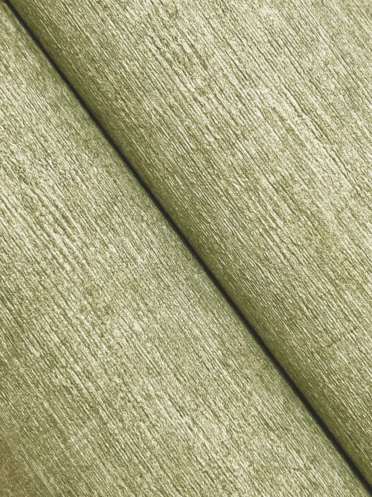 Close-up of two parallel strips of Chesapeake Tansy Distressed Wallpaper by York Wallcoverings, featuring a textured, light greenish surface, running diagonally from top left to bottom right.