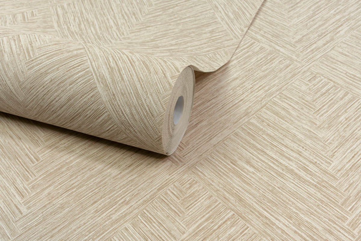 A roll of Chesapeake Hollis Textured Diamond Wallpaper by York Wallcoverings, featuring a beige geometric texture, is partially unrolled on a matching surface.