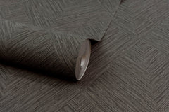 A roll of Chesapeake Hollis Textured Diamond Wallpaper by York Wallcoverings, featuring a geometric brown herringbone pattern, lies on a matching surface.