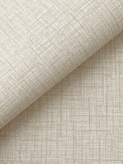 A close-up of Beau Faux Fabric Wallpaper by York Wallcoverings, featuring textured beige material with a subtle grid and crosshatch pattern, partially rolled atop a flat surface covered in the same wallpaper.