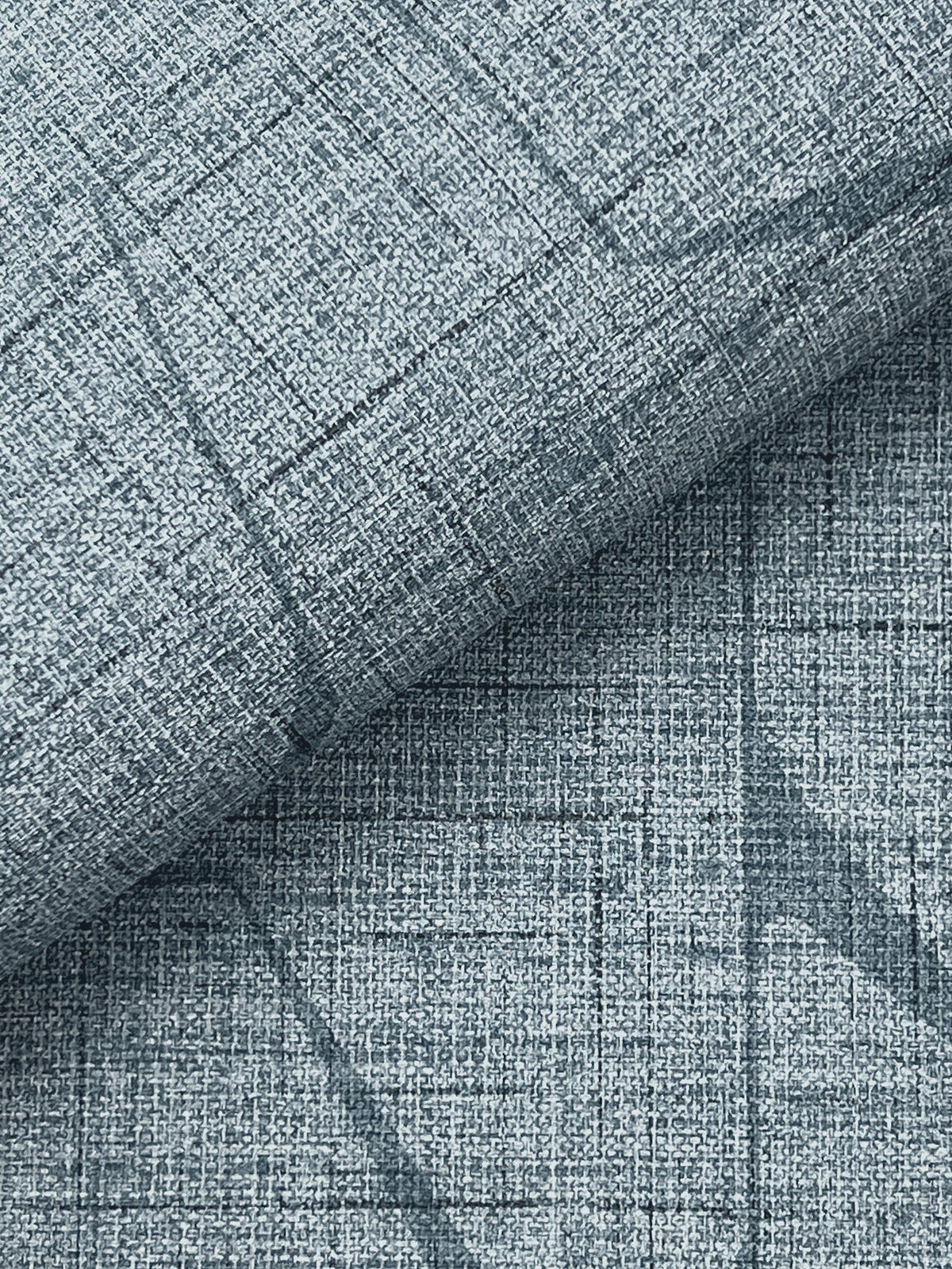 Close-up of Lyle Abstract Geometric Wallpaper by York Wallcoverings in light blue, featuring a textured surface with a subtle crisscross grid pattern and visible linear, woven details.