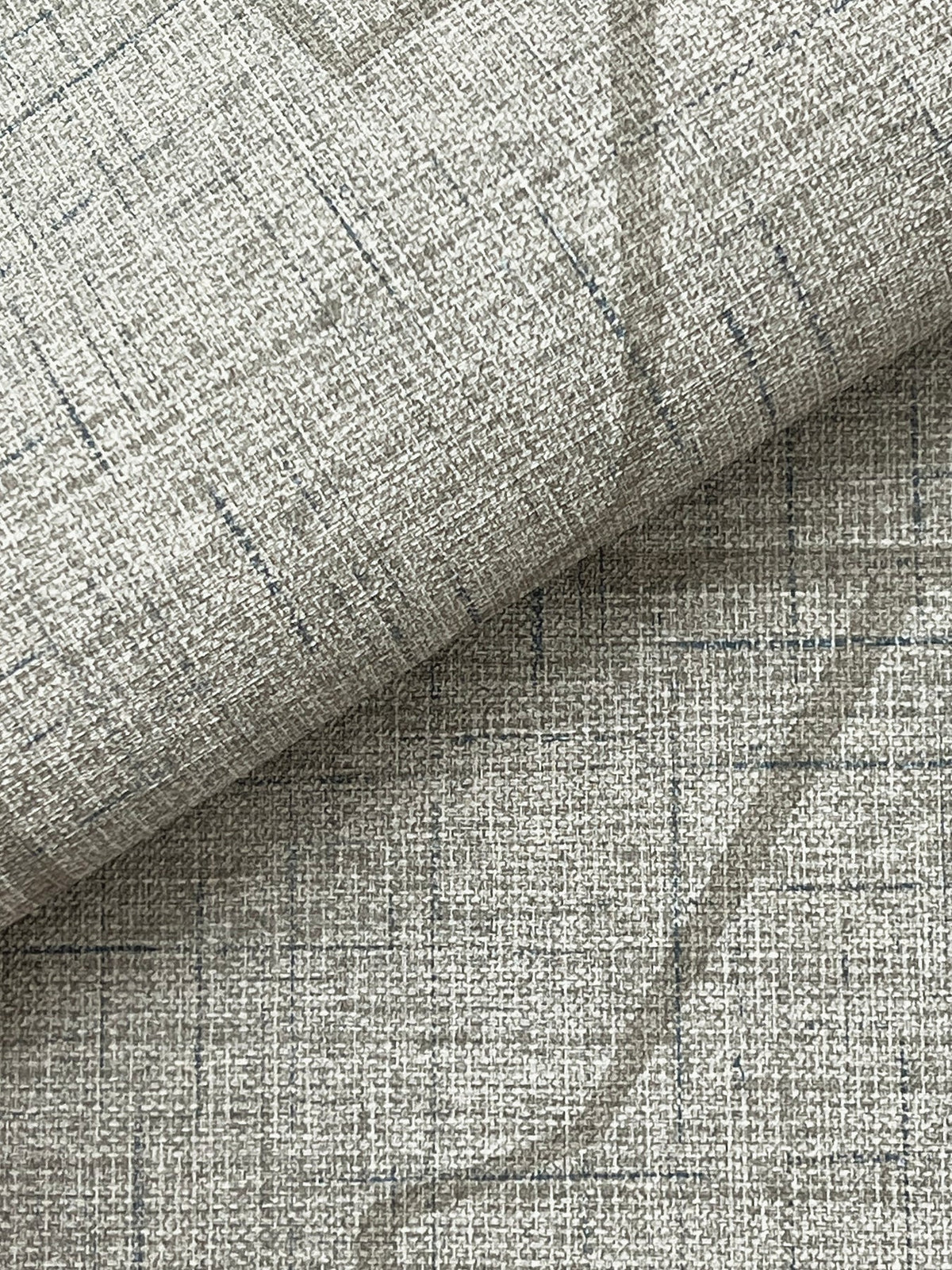 Close-up of the Lyle Abstract Geometric Wallpaper by York Wallcoverings in light gray, featuring a subtle grid pattern and visible weave with thin intersecting lines. A folded section highlights the minimalist, modern aesthetic of the design.