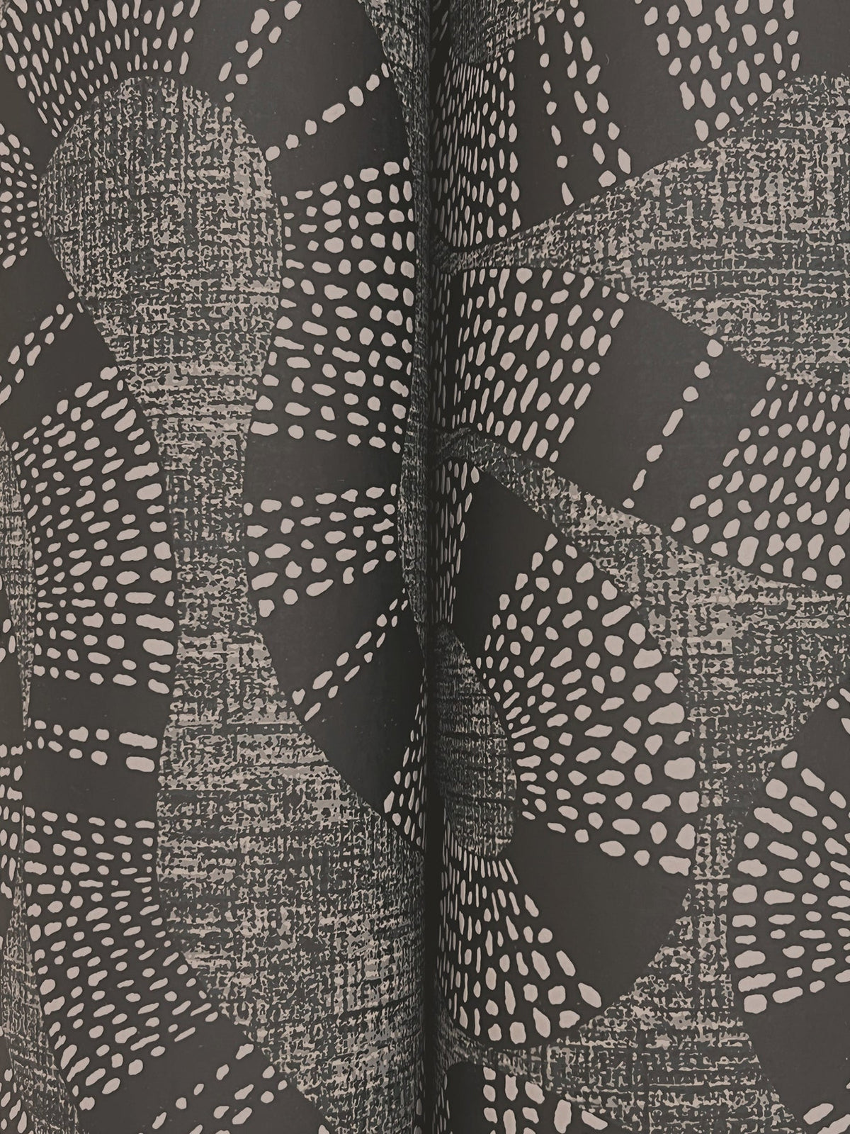 Experience the dynamic, textured design of the Ophidia Wallpaper by York Wallcoverings, featuring an abstract black and white patterned surface with wavy lines and dotted shapes. Two prominent vertical ridges in the center divide the composition, adding depth to its striking appearance.