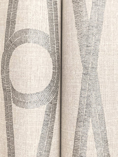Close-up of Henlein Wallpaper by York Wallcoverings, featuring light-colored textured material adorned with gray-stitched geometric patterns, including a circle and intersecting lines.