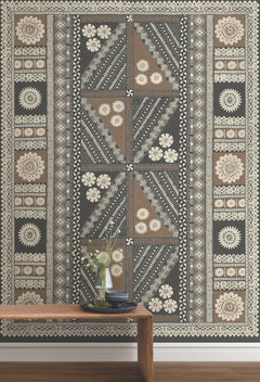 A Tapa Mural Wall Mural featuring geometric shapes and floral motifs in black, brown, and cream tones is displayed with a wooden bench in front, adorned with vases and books.