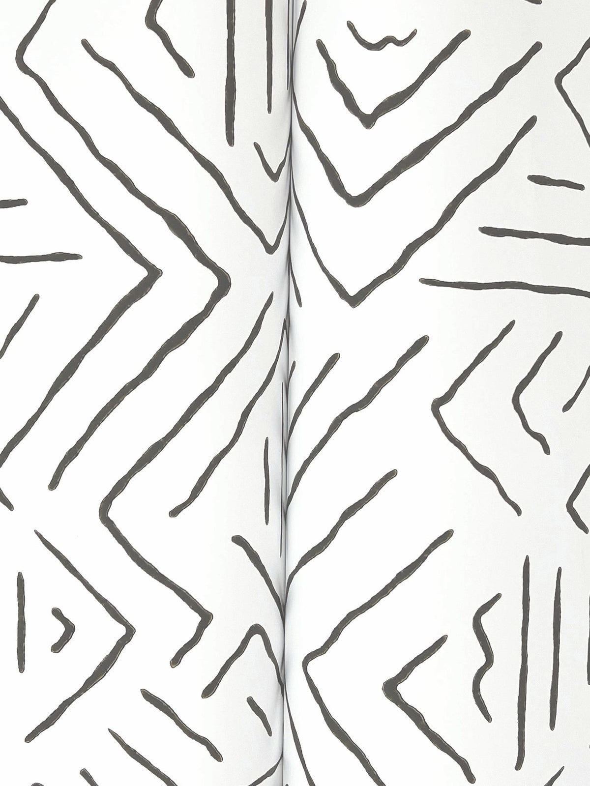 Black zigzag and chevron-like hand-drawn lines form a geometric pattern on a white background in the Sirih Wallpaper by York Wallcoverings.