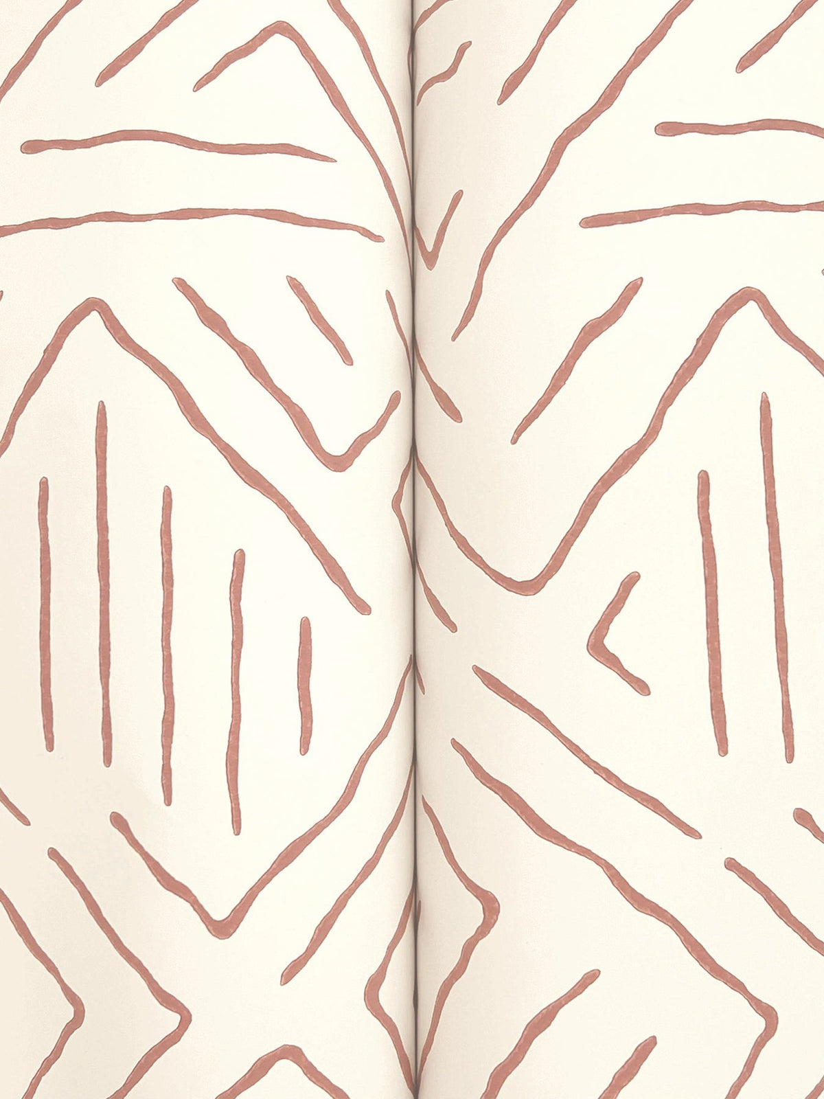 The Sirih Wallpaper by York Wallcoverings features an abstract pattern of brown, uneven lines creating diamond and zigzag shapes on a cream background, with a visible central seam indicating the image spans two pages.