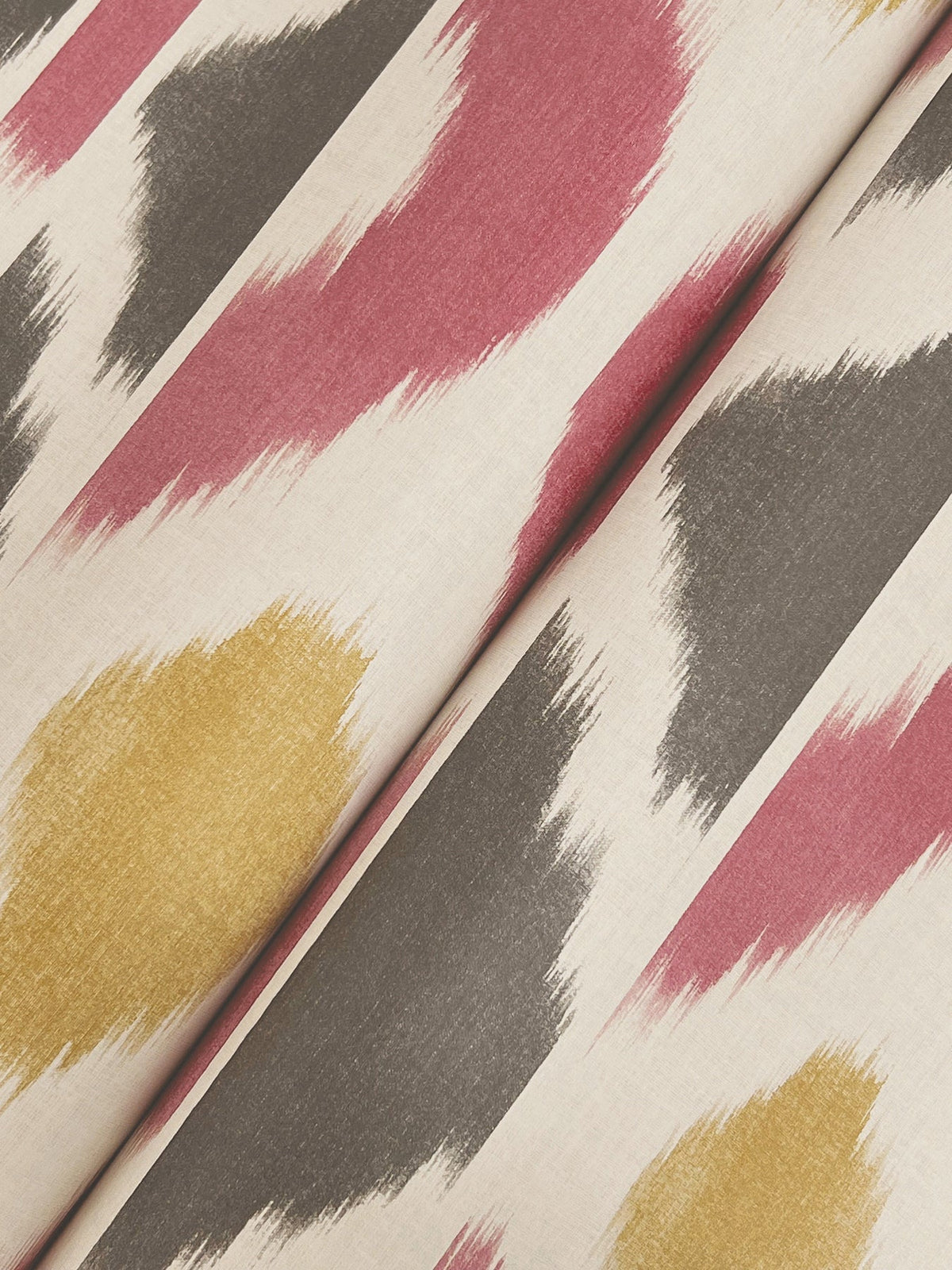 Patan Wallpaper by York Wallcoverings features a cream background adorned with bold, diagonal brushstroke patterns in red, yellow, and gray, creating a modern and abstract aesthetic.