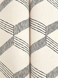 Two rolls of York Wallcoverings’ Palisades Paperweave Wallpaper, featuring a geometric black zigzag and line pattern on a light beige background, are displayed side by side with the designs precisely aligned.
