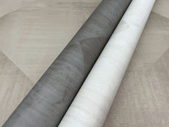 Two rolls of In Clay Wallpaper featuring a subtle geometric pattern in charcoal and off-white.