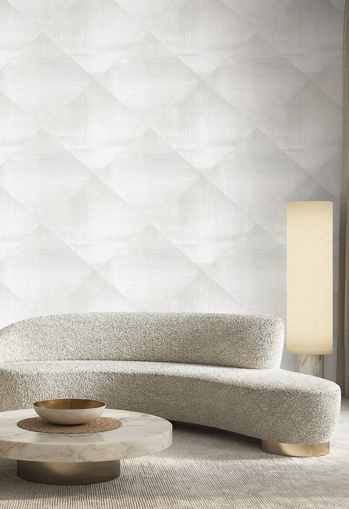 In Clay Wallpaper by York Wallcoverings in a light gray repeating diamond pattern on a wall behind a curved sofa, a marble coffee table, and a tall floor lamp.