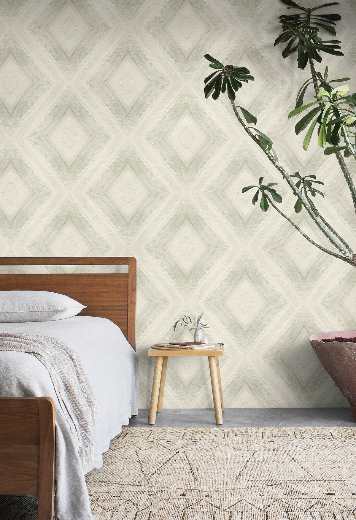 A bedroom wall featuring Ballad Wallpaper, which displays a large-scale, soft-edged diamond pattern in neutral tones.