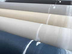 Five horizontal rolls of Ink Wash Wallpaper by York Wallcoverings, each featuring a different color with a streaked, ink-wash pattern.