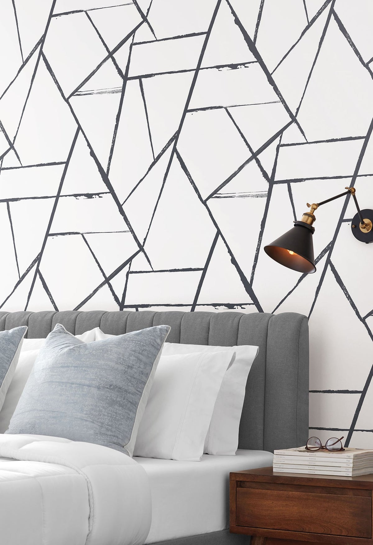 Intersect Wallpaper featuring a geometric pattern of overlapping black lines on a white background installed behind a bed.