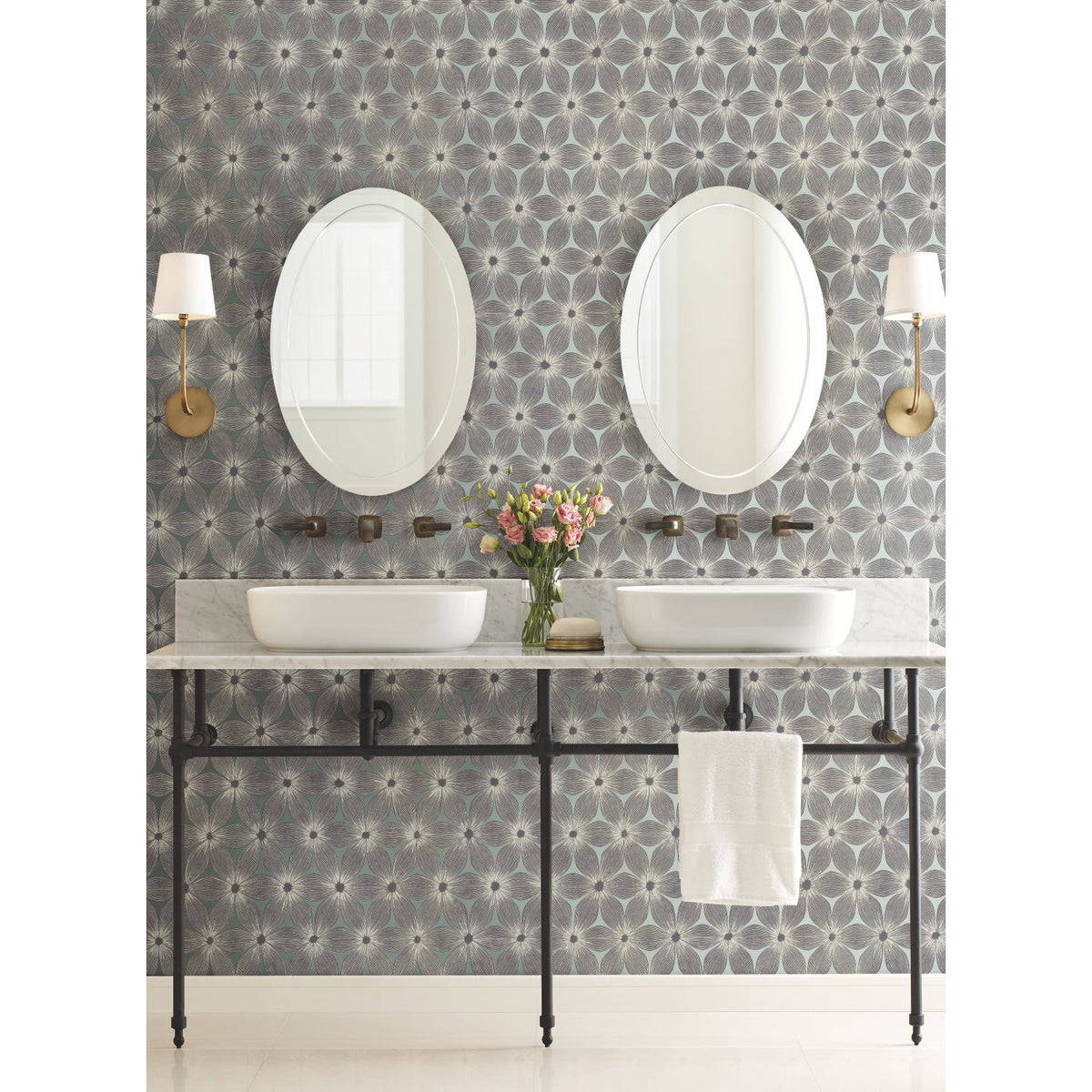 A bathroom vanity with two oval mirrors and vessel sinks set against Candice Olson Everlasting Wallpaper by York Wallcoverings.