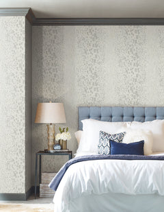 A bedroom featuring walls covered in Candice Olson Gilded Confetti Wallpaper, which has a repeating pattern of small, metallic-colored rectangles on a gray background.