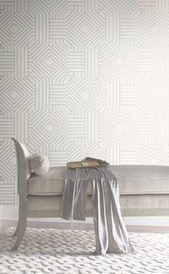 A tufted bench with a silk scarf and gold clutch sits against Candice Olson Diverging Diamonds Wallpaper by York Wallcoverings, featuring a geometric pattern of interlocking diamonds and lines.
