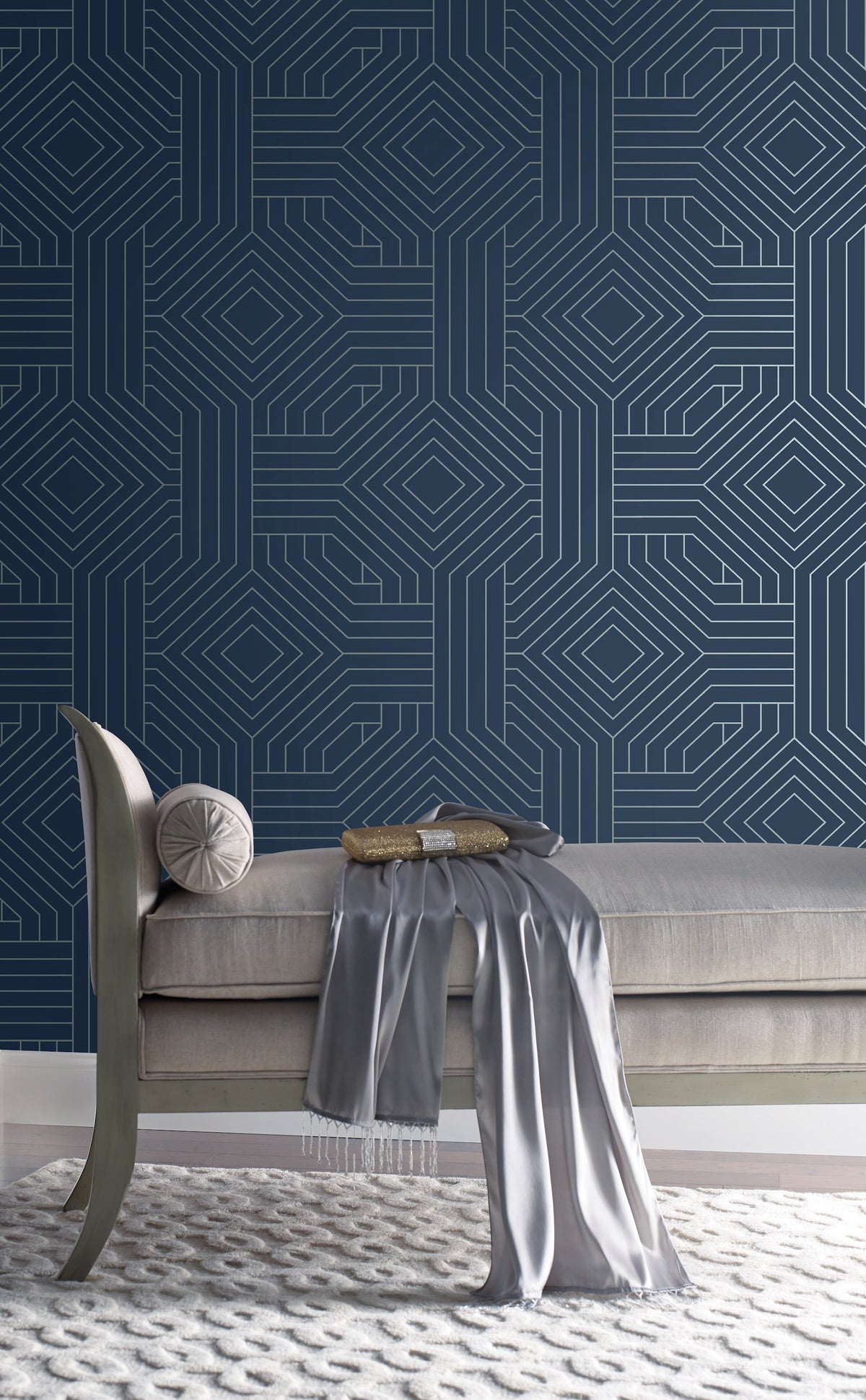 A bench sits in front of a wall covered in navy blue Candice Olson Diverging Diamonds Wallpaper by York Wallcoverings, featuring a white geometric pattern of interlocking diamonds.