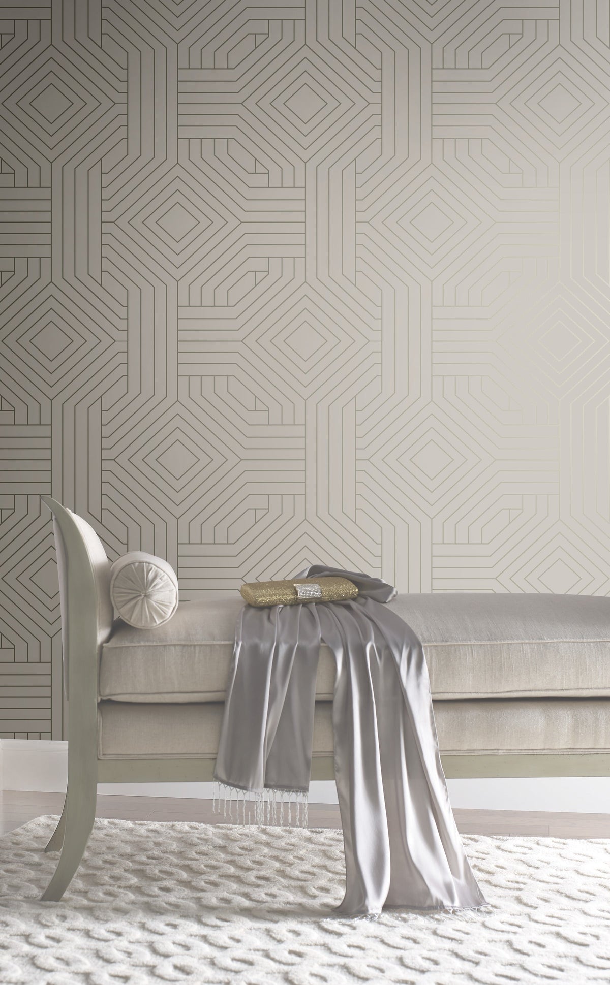 Candice Olson Diverging Diamonds Wallpaper by York Wallcoverings featuring a geometric pattern of gold lines forming interlocking diamonds against a neutral background, positioned behind a tufted bench.