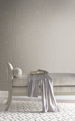 Candice Olson Diverging Diamonds Wallpaper by York Wallcoverings featuring a geometric pattern of gold lines forming interlocking diamonds against a neutral background, positioned behind a tufted bench.