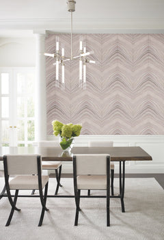 Dining room with a dining table and chairs set against a wall featuring York Wallcoverings Candice Olson Onyx Strata Wallpaper with a light-toned, chevron-like wave pattern.