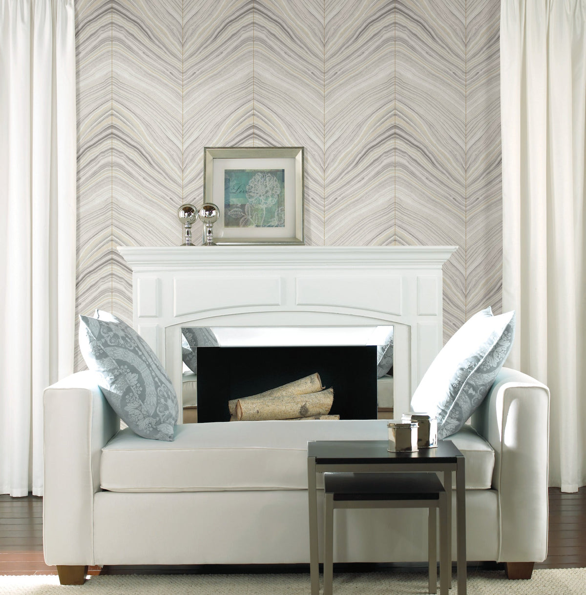 White sofa positioned in front of a fireplace with Candice Olson Onyx Strata Wallpaper by York Wallcoverings in the background.