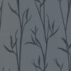 The Matcha Wallpaper by York Wallcoverings features dark blue silhouettes of leafy branches on a muted gray background, creating a simple botanical pattern with a natural, elegant feel.