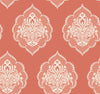 The Signet Medallion Damask Wallpaper by York Wallcoverings features an elegant, vintage-inspired design with ornate white floral motifs arranged in a seamless pattern over a muted coral background.