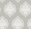 Signet Medallion Damask Wallpaper by York Wallcoverings features a repeating ornate white medallion damask pattern with floral and swirl details set against a muted gray background. This symmetrical, vintage-inspired design creates a classic and elegant wallpaper look.