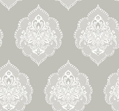 Signet Medallion Damask Wallpaper by York Wallcoverings features a repeating ornate white medallion damask pattern with floral and swirl details set against a muted gray background. This symmetrical, vintage-inspired design creates a classic and elegant wallpaper look.